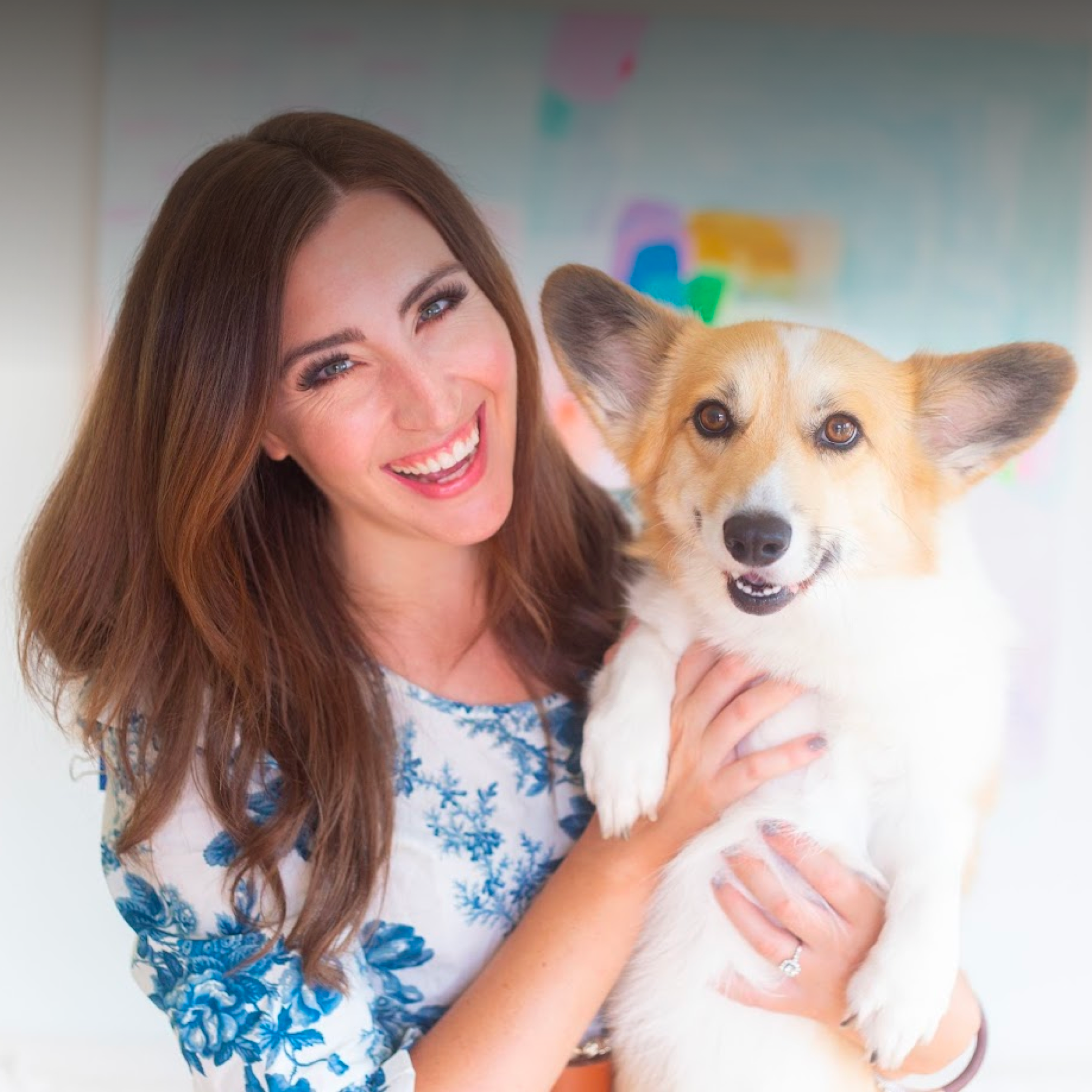 A young woman poses with her corgi